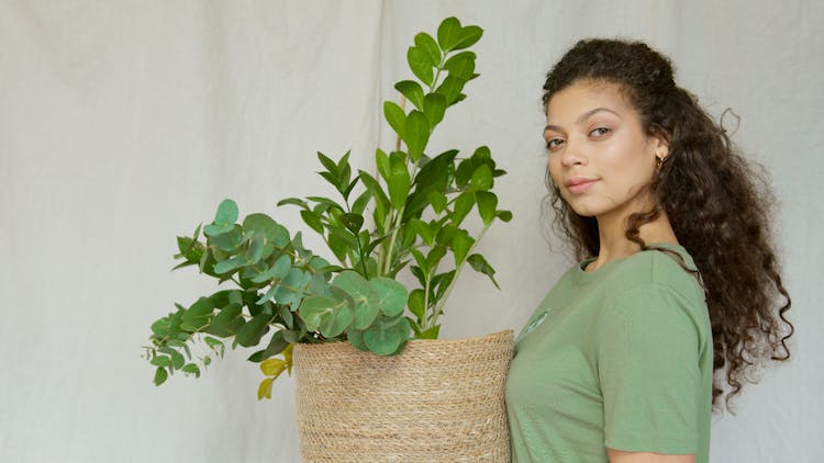 Woman Carrying A Green Plant