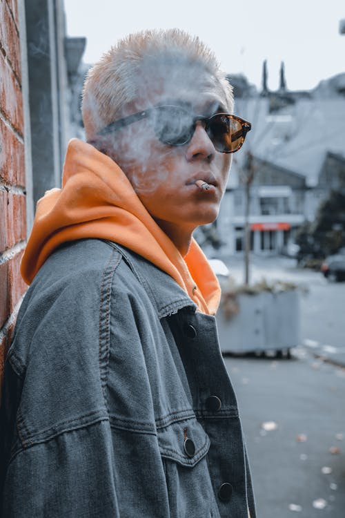 Man in Denim Jacket Smoking Cigarette