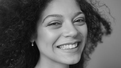 Grayscale Photo of a Woman Smiling