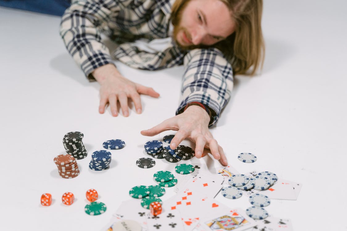 Free Man Reaching for Poker Chips Stock Photo