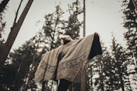 在秋叶环绕的森林中，裹着舒适的民族毛毯，享受宁静的散步