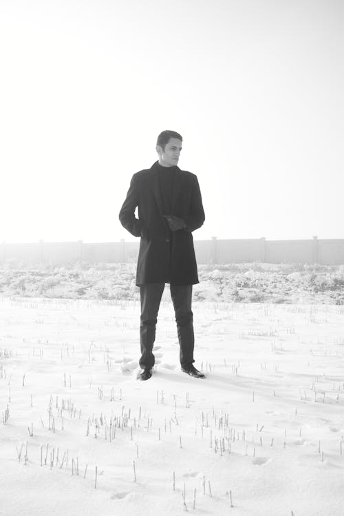 Man in Black Coat Standing on Snow