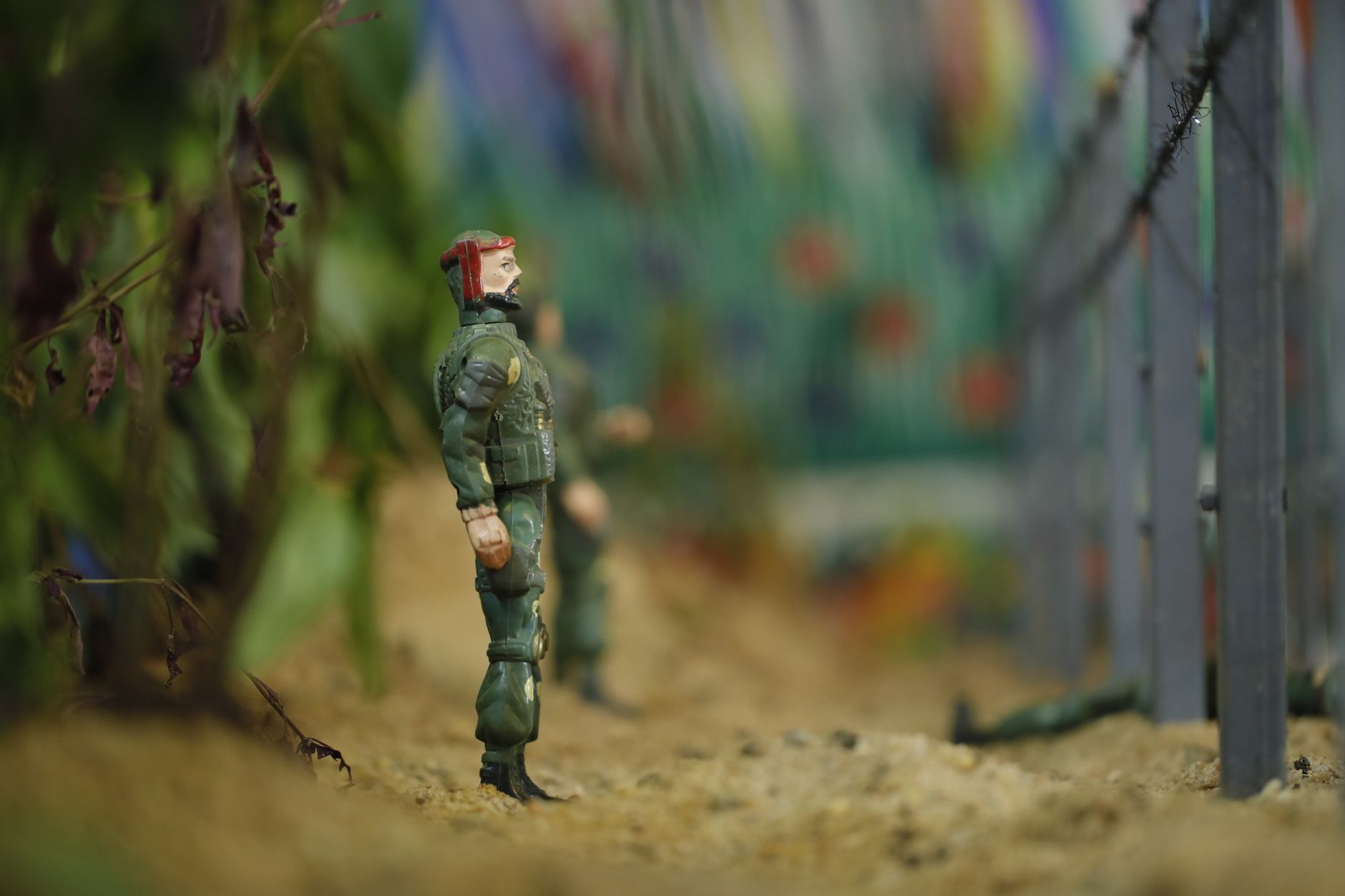 Close-up of toy soldiers in military uniform standing in a simulated environment with blurred background.