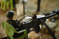 Black and Green Rifle on Brown Textile