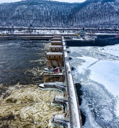 Free Aerial view of a dam amidst snowy hills in Minnesota during winter. Stock Photo