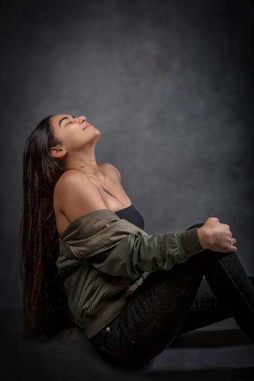 Beautiful Woman Wearing a Green Jacket Posing in a Photographic Studio