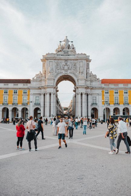 People walking at the Arco da Rua Augusta in Lisbon, a stunning architectural landmark.