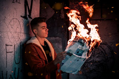 Man Holding a Burning Newspaper