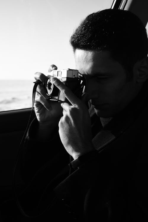 Man in Black Coat Holding Camera