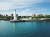 海湾旁的灯塔景色美丽，背景是城市天际线