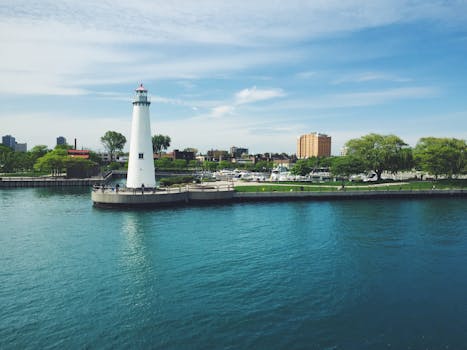 海湾旁的灯塔景色美丽，背景是城市天际线