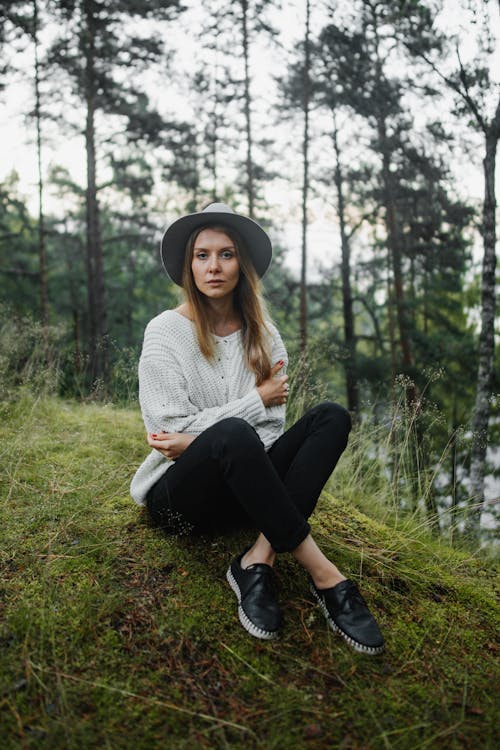 A Woman Sitting on Grass in the Woods