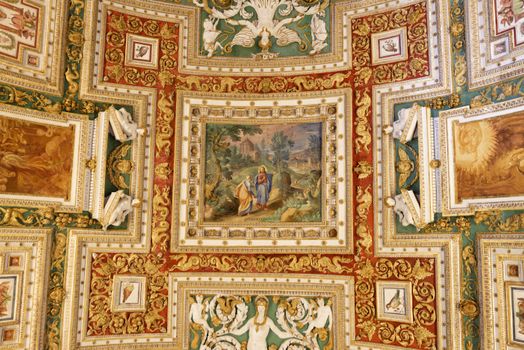 Intricate ceiling art depicting historical and religious scenes inside the Vatican Museum.