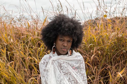 Woman in Lace Shawl Standing Near Tall Grass 