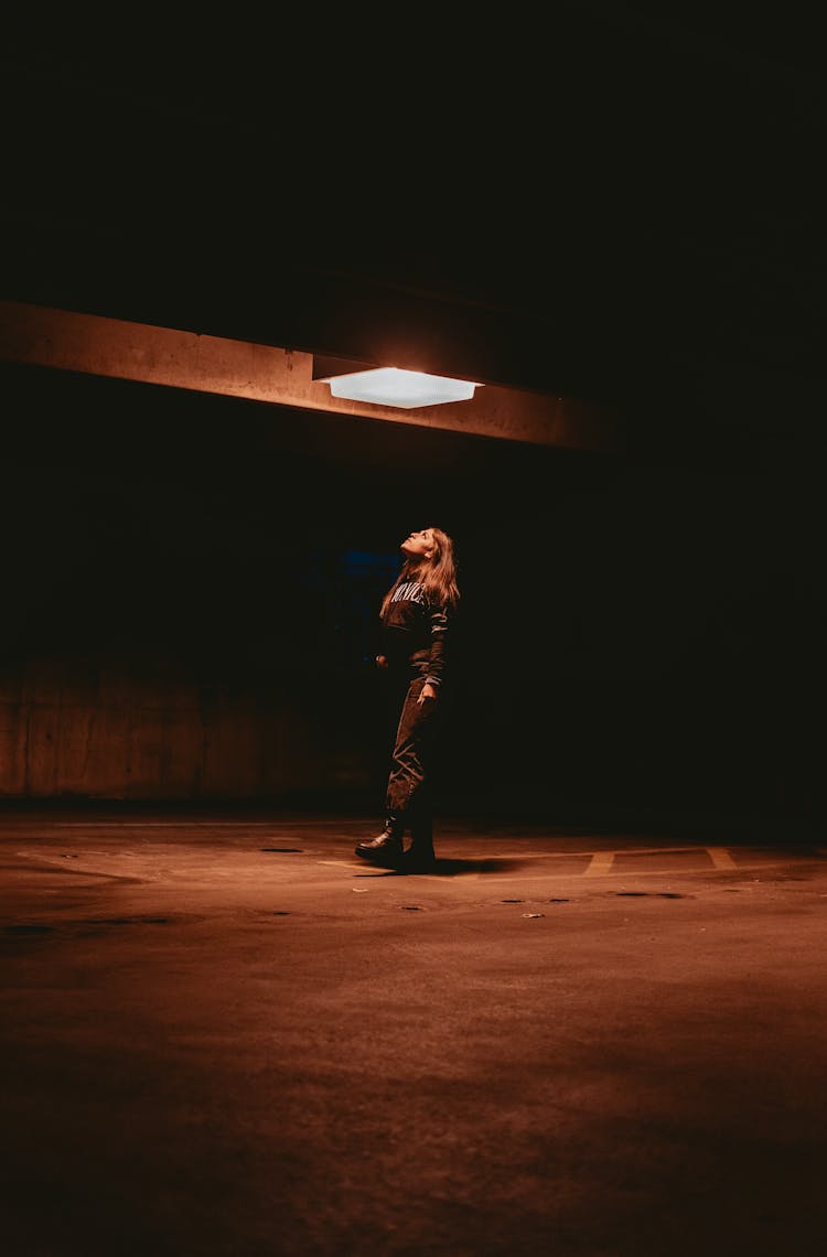 Woman In Black Long Sleeve Shirt And Pants Below The Ceiling Light