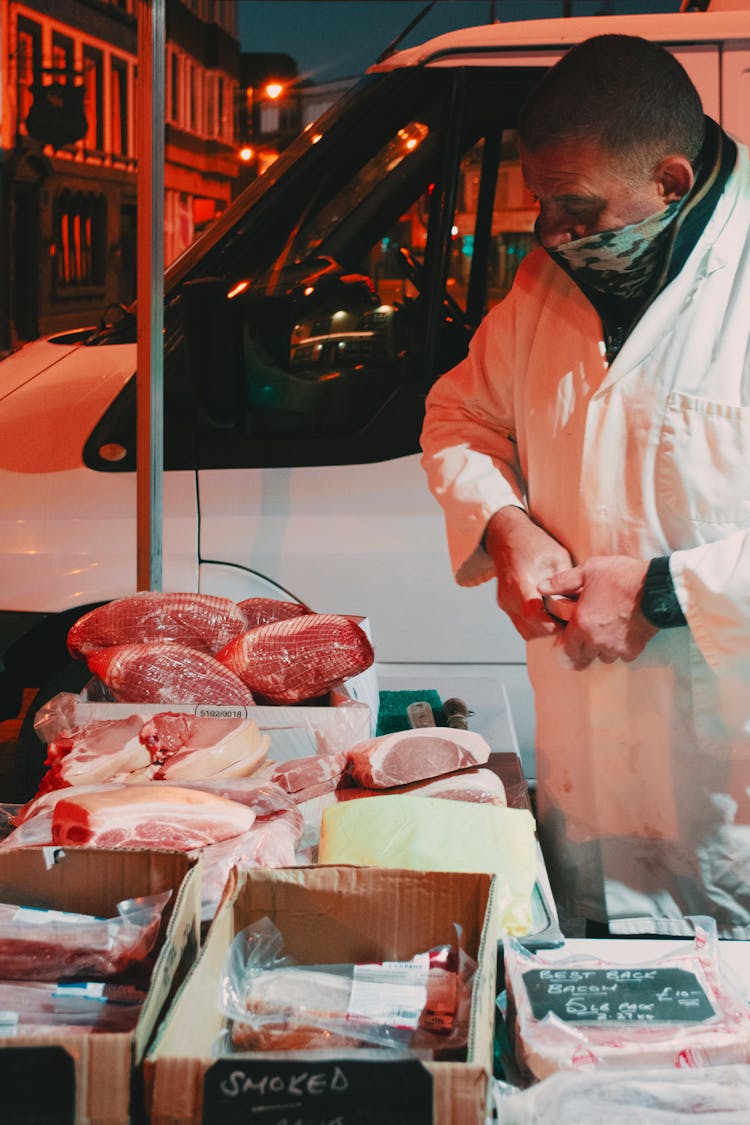 Butcher Standing Behind Displayed Meat 