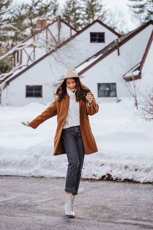 Photo of a Woman in a Brown Coat Dancing