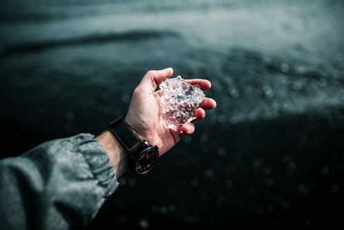 Photo of a Person's Hand Holding a Piece of Ice