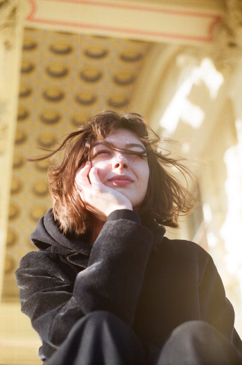 Low-Angle Shot of a Woman Posing with Her Hand on Her Chin