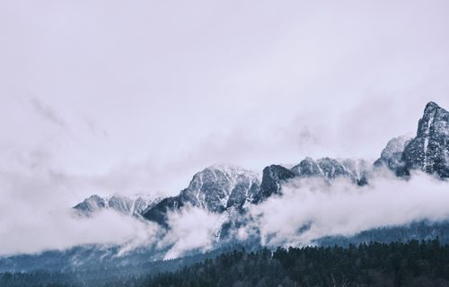 Free Capture of a stunning mountain range with snow caps and cloudy sky, showcasing nature's beauty. Stock Photo