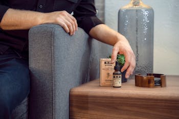 Person Holding Black Labeled Bottle