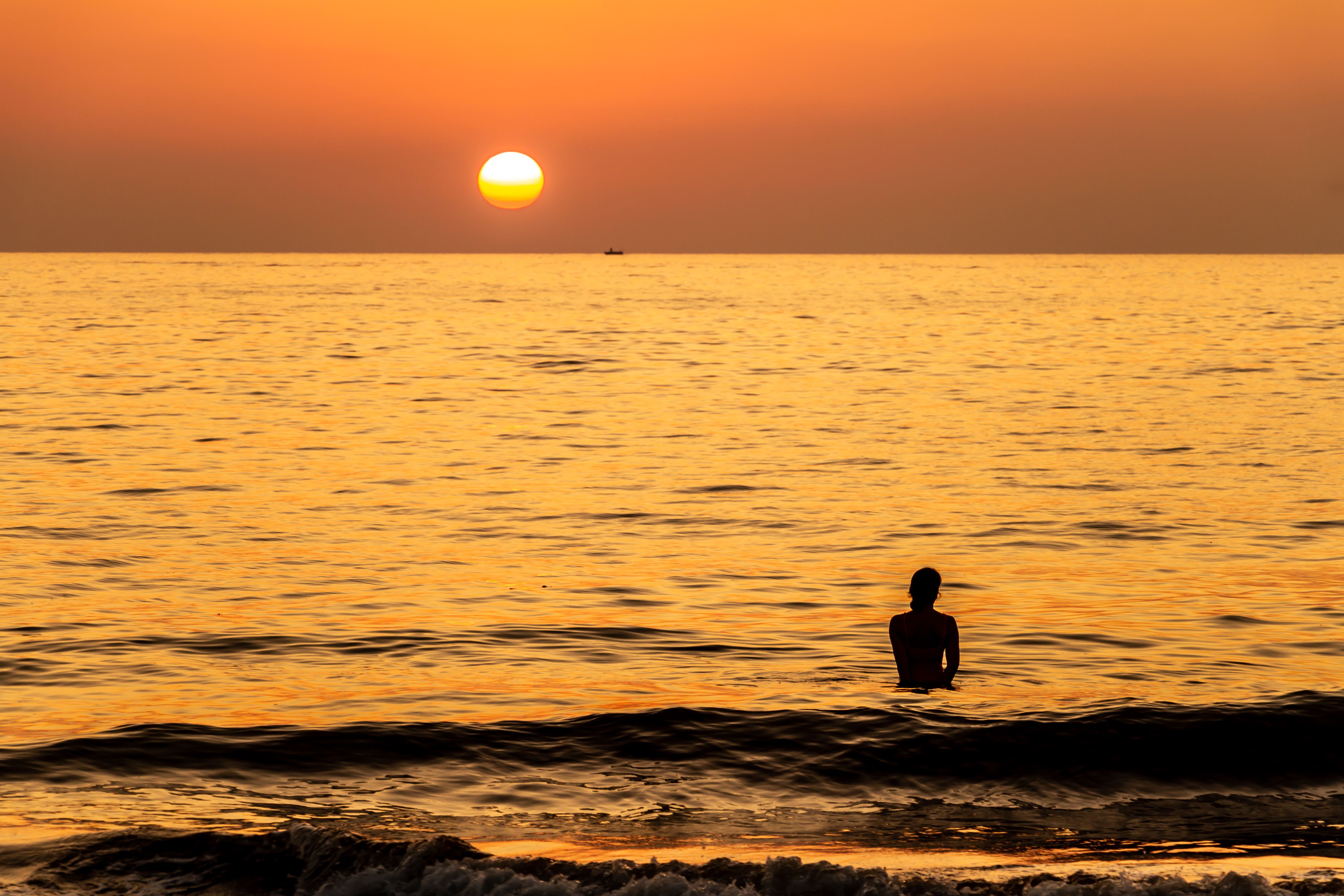 Silhouette of Person in Body of Water During Sunset · Free Stock Photo