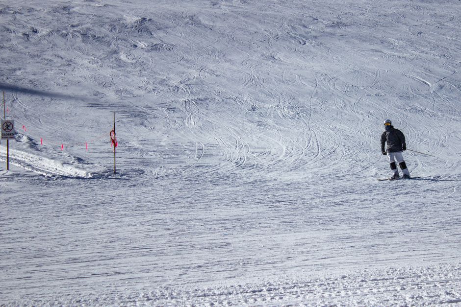 A skier glides down a snowy slope in Winter Park, Colorado, enjoying a bright winter day.