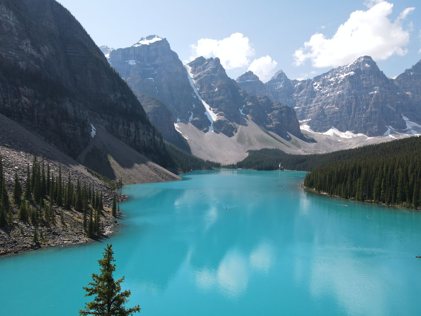 Breathtaking view of Moraine Lake's turquoise waters surrounded by the Rockies in Banff National Park, Alberta.