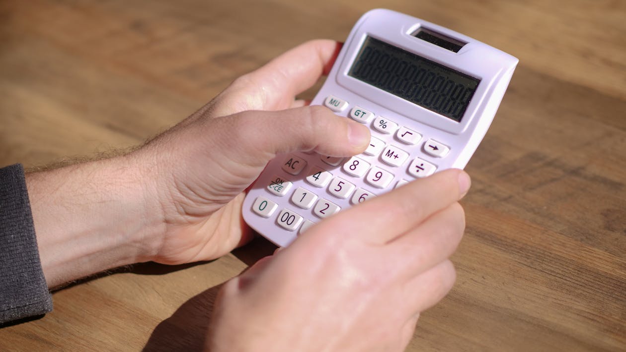 Free Photo of a Person Using a White Calculator Stock Photo
