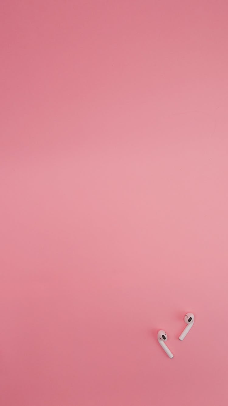 Wireless Earphones On A Pink Background