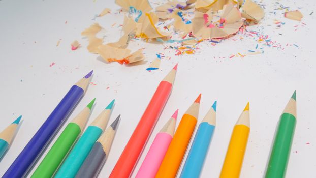 A collection of colorful pencils with shavings on a white background, ideal for creative projects.