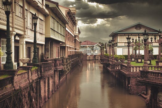 Scenic view of Spanish colonial-style buildings along a canal in Bagac, Philippines.