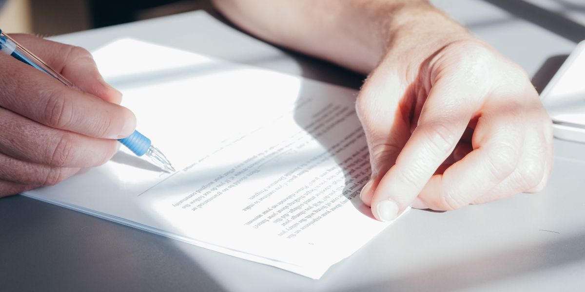 Mains signant un contrat avec un stylo bleu