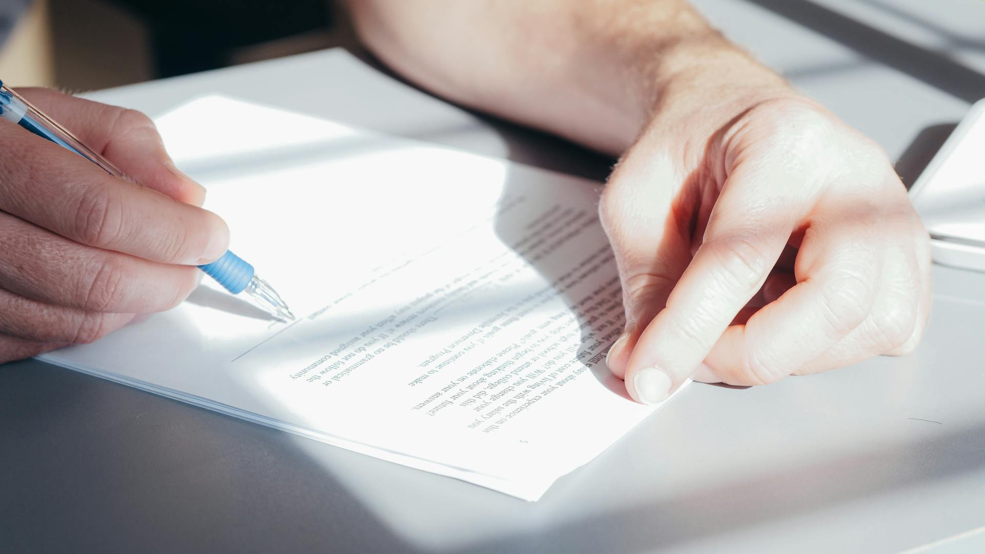 A Person Signing a Document