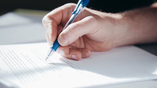 A Person Writing on a Paper 