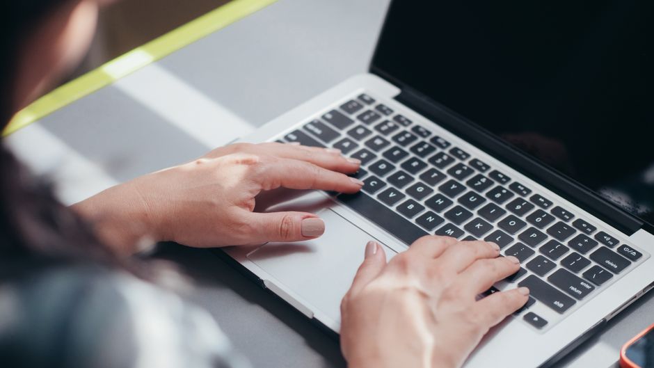 person writing email laptop desk