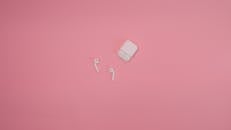 Earbuds on a Pink Surface