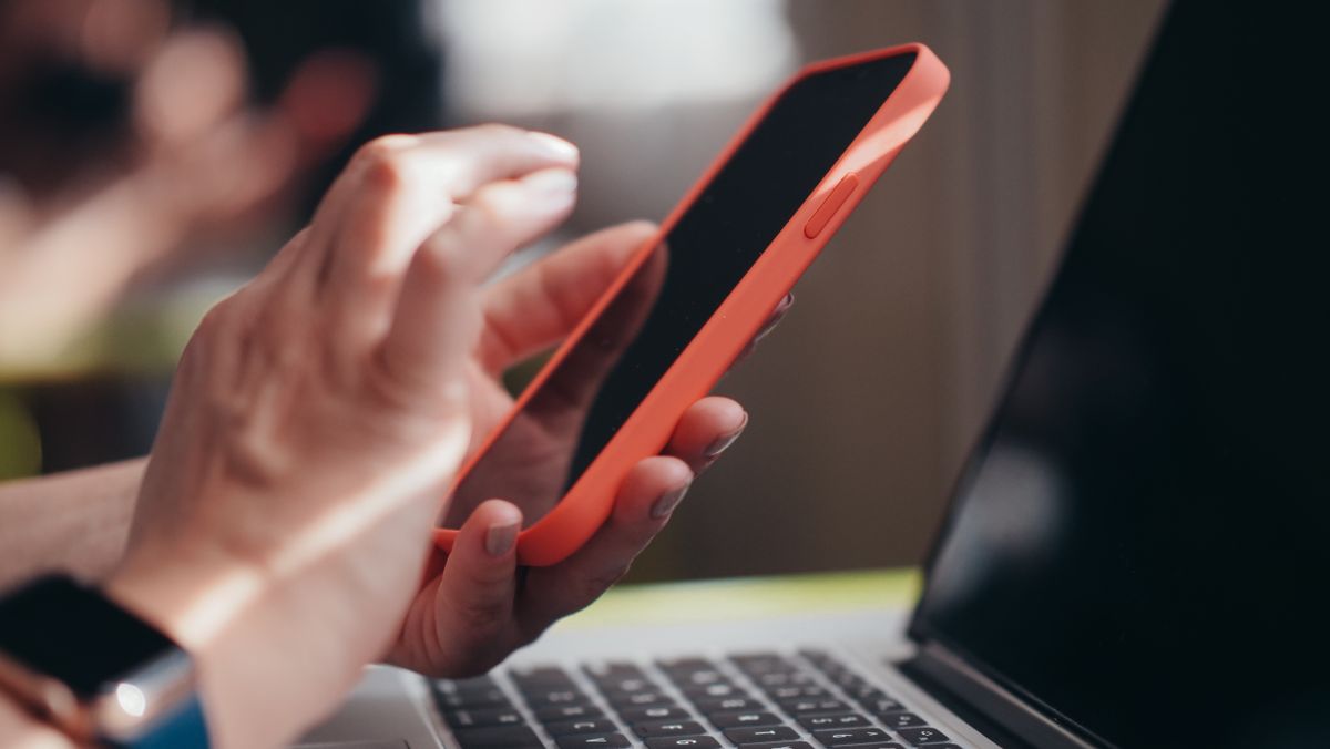 Canlı maç bahsi için skoru takip eden kişi elinde akıllı telefon tutuyor
