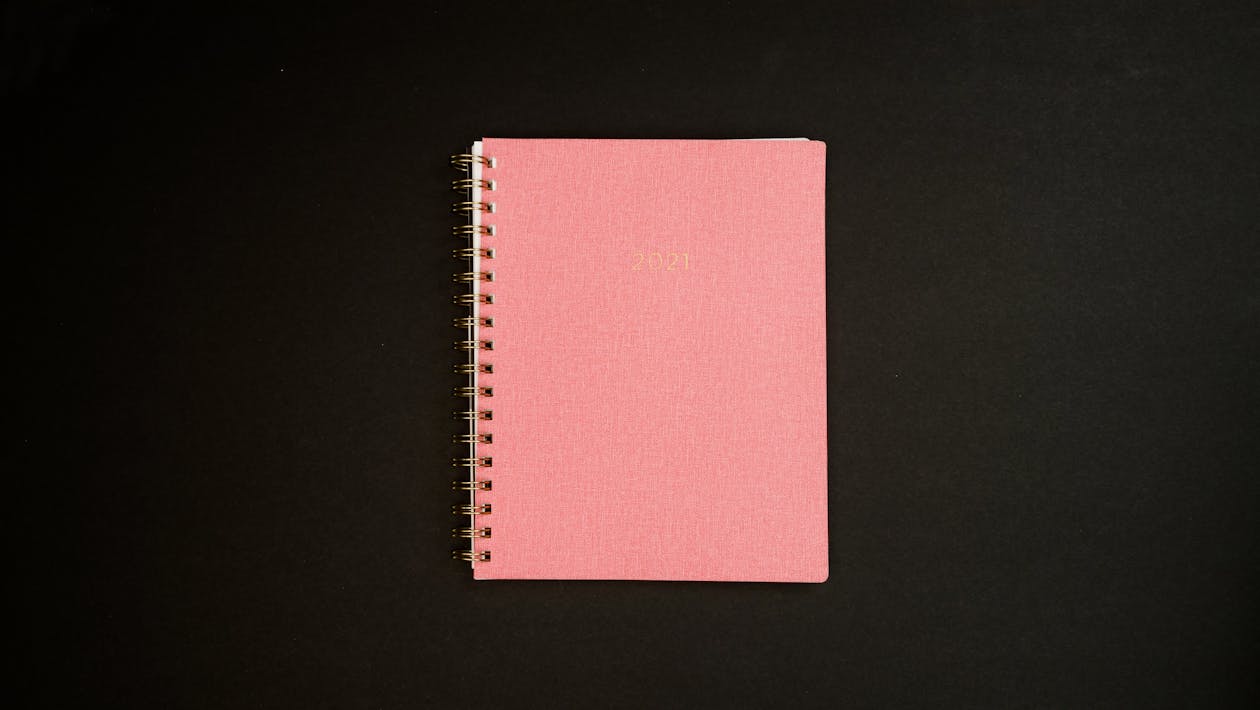 Free Overhead Shot of a Pink Notebook Stock Photo