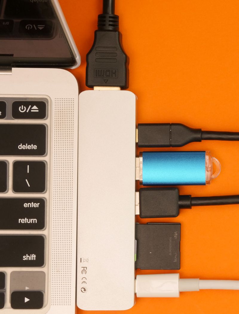 Close-up of a USB hub with multiple connections attached to a laptop, highlighting efficient cable management.