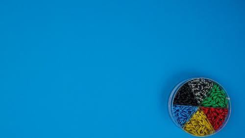 Close-Up Shot of Paper Clips in a Plastic Container