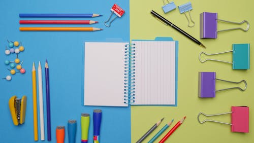 Free Colorful Pens and Stationaries on Blue and Yellow Surface Stock Photo