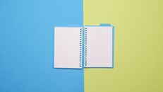 White Notebook on Yellow Table