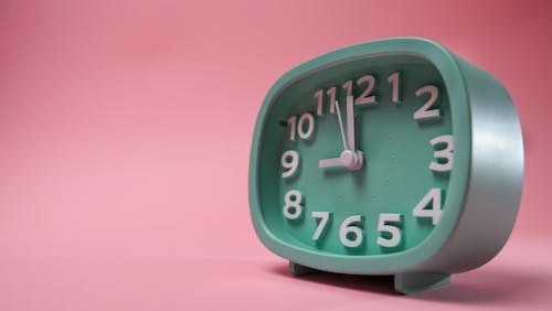 Close-up of a Green Alarm Clock on Pink Background