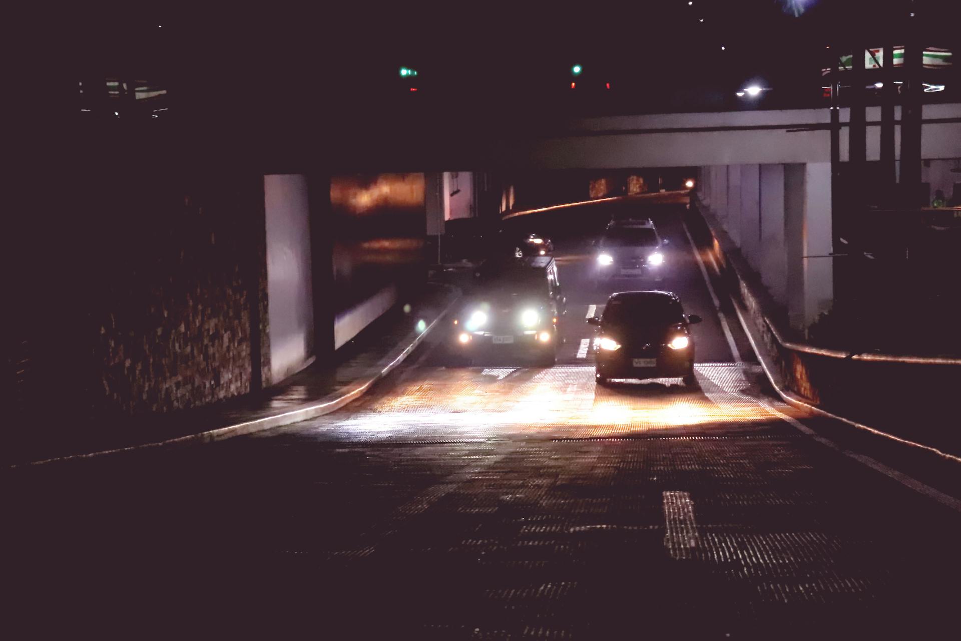 Illuminated cars driving through a tunnel in Makati, Philippines at night.