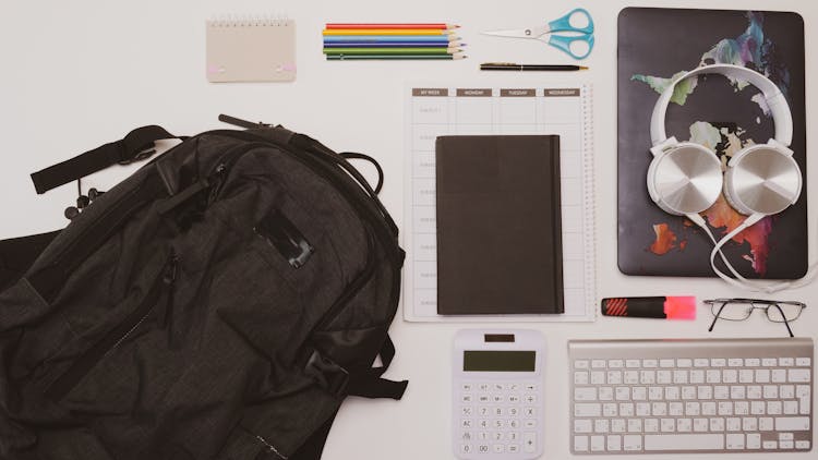 Overhead Shot Of A Backpack Near A Calculator