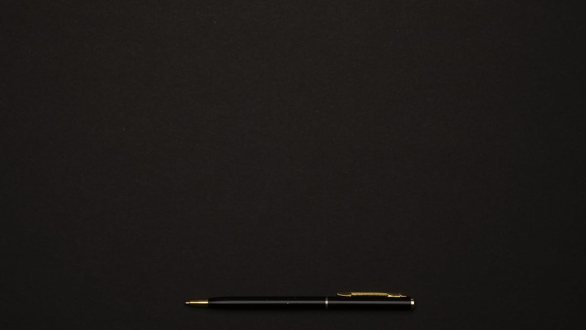 Clean aesthetic study desk setup with laptop, keyboard, and notebook