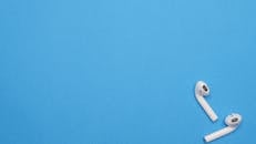 White Wireless Earphones on a Blue Surface