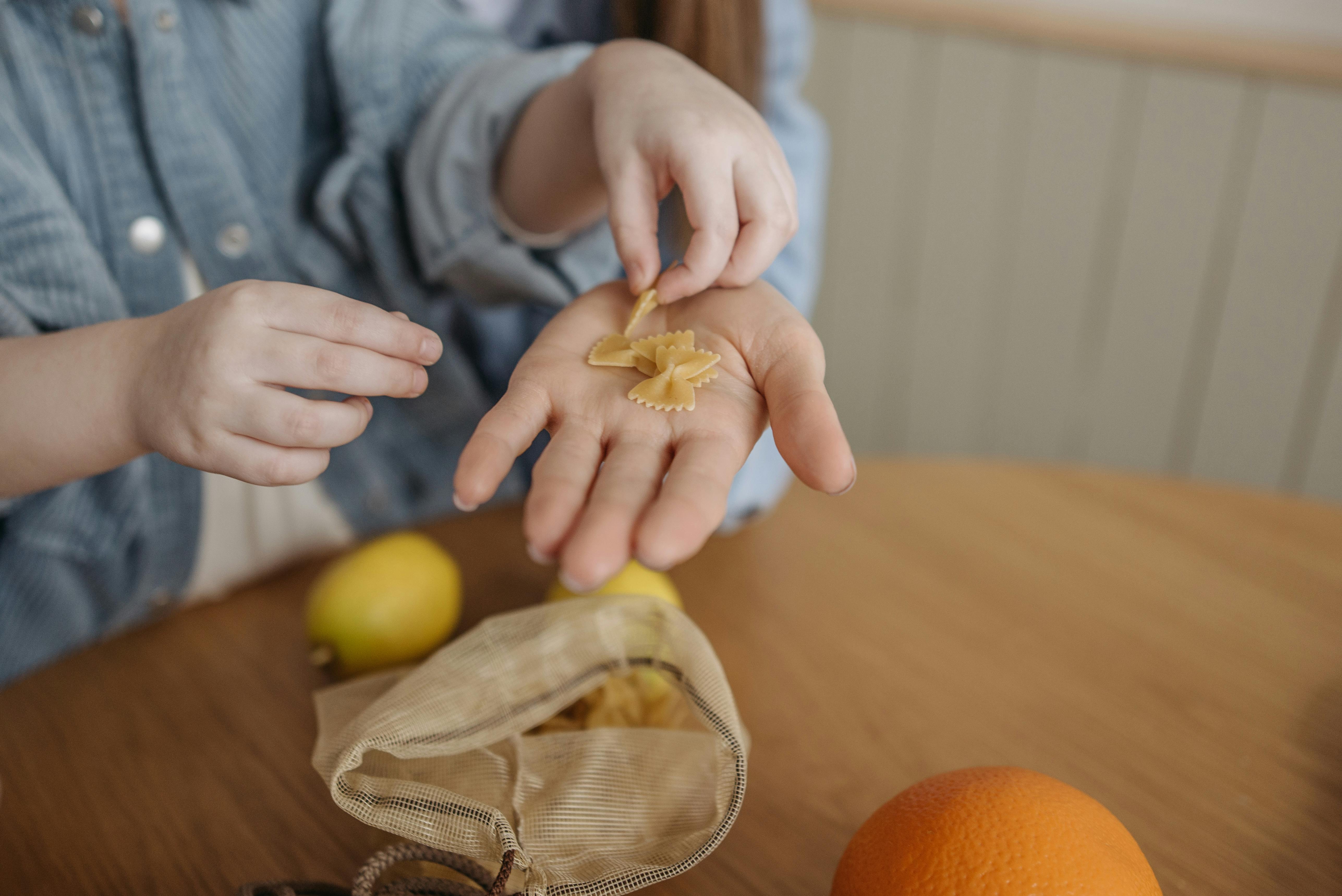 hands of a child placing pasta on a woman s palm