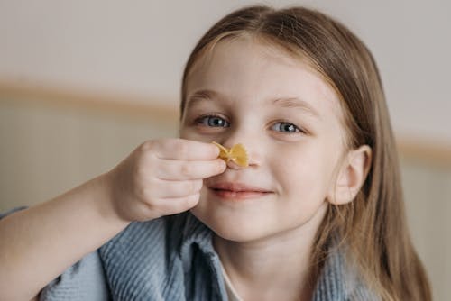 Free Photo of a Girl Holding a Piece of Pasta Stock Photo